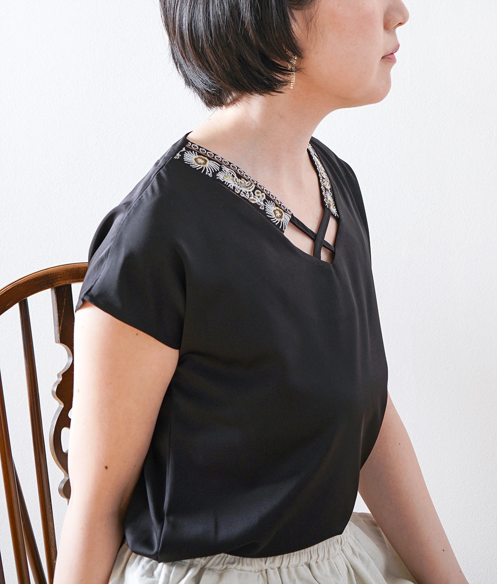 Glossy blouse with embroidery and cross lines
