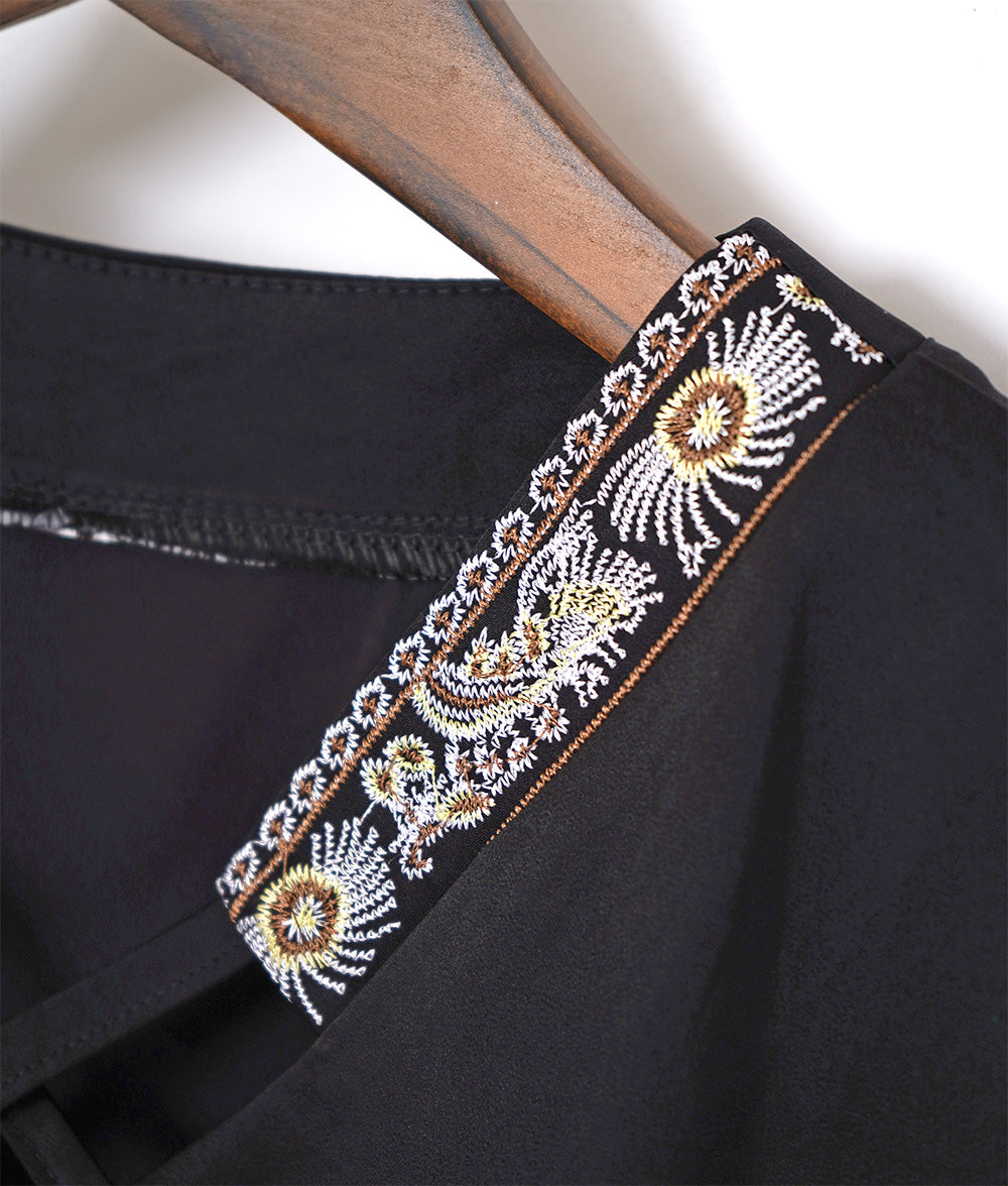 Glossy blouse with embroidery and cross lines
